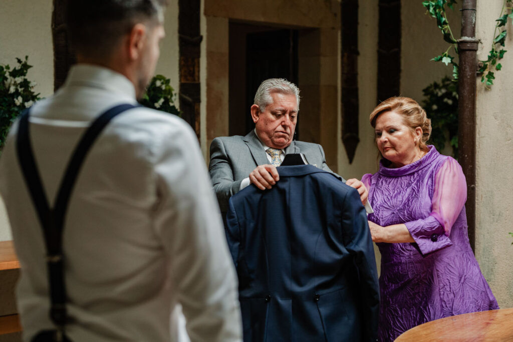 Boda-palacio-valdesoto-asturias Padres ayudando al novio al vestirse